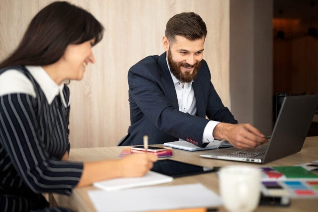 Professionals collaborating using SpineLegal Software on a laptop in an office setting.