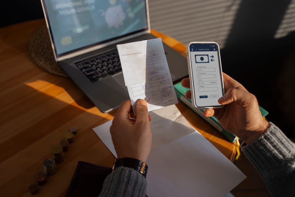 Person using SpineLegal Software for managing finances on smartphone and laptop.